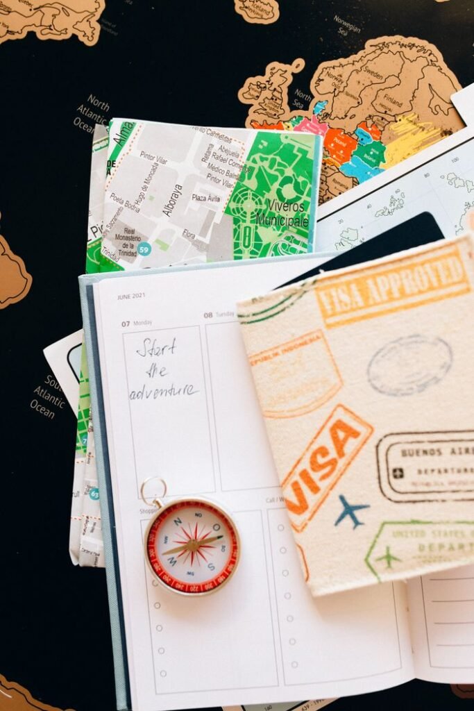 Flat lay of travel essentials including compass, notebook, and map for a journey international travel companies